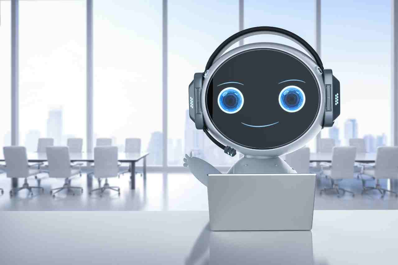 Robot amigable con auriculares trabajando en una computadora en una sala de conferencias moderna