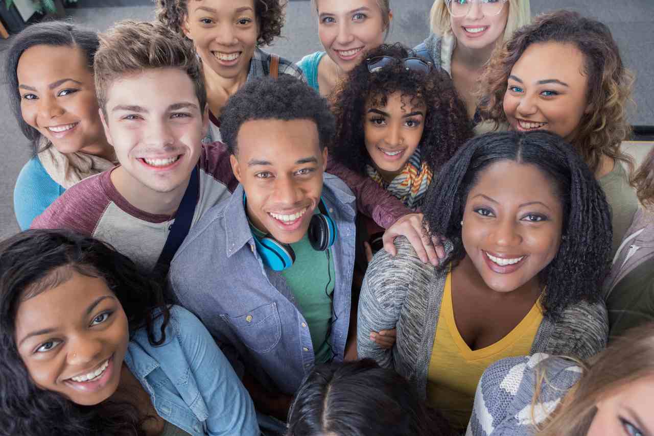 Grupo de alumnos sonriendo a una cámara en alto